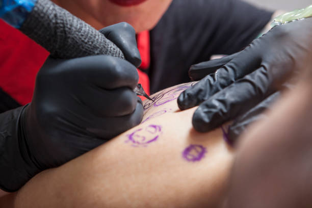 istock Tattoo artist outlines a tattoo 673873196