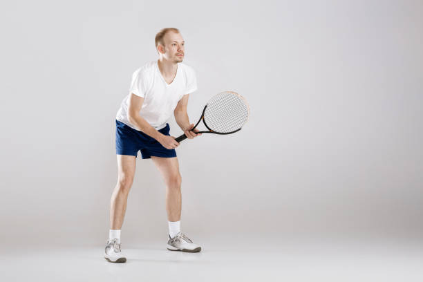 istock young tennis player plays tennis on grey background 673891878