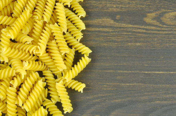 istock Fusilli pasta on dark wood background 673891926