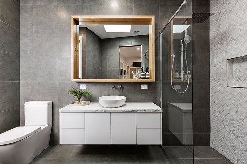 Baño moderno de diseño gris con azulejos de ducha de espiga photo