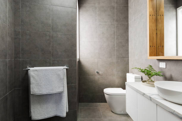 Charcoal grey modern bathroom with marble benchtop and wood mirror