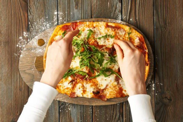 istock Home made pizza on wooden table 673903666