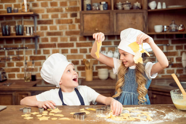 istock excited kids playing with dough for shaped cookies in kitchen 673904462