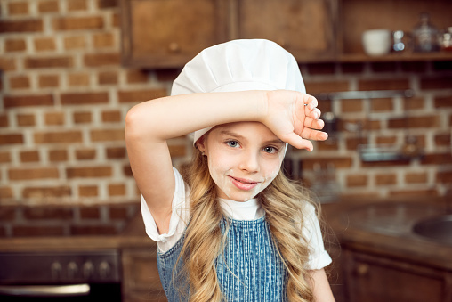 Young beautiful girl wearing chef hat uniform over isolated background smiling making frame with hands and fingers with happy face. Creativity and photography concept.