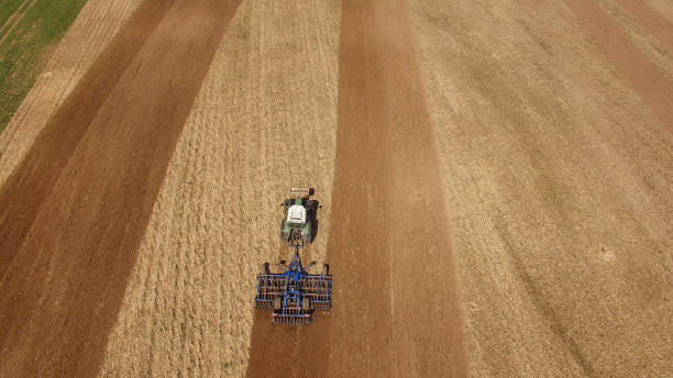 istock aerial view of a tractor at work on a beautiful agricultural fields in spring - top view 673909438