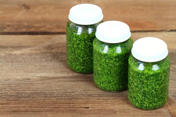 istock Homemade pesto in jars on rustic wooden table 673909460
