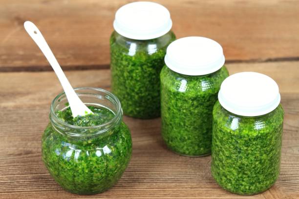 istock Homemade pesto in jars on rustic wooden table 673909564
