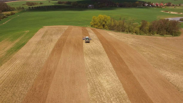 istock Aerial view of beautiful agricultural fields in spring with a tractor at work - cultivating a field 673909680
