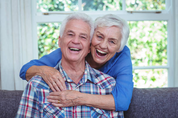 istock Senior woman laughing while embracing husband from behind 673914490