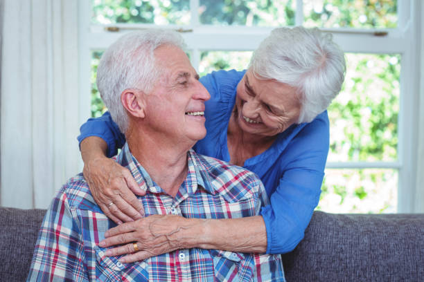 istock Cheerful wife embracing while looking at senior man 673914602