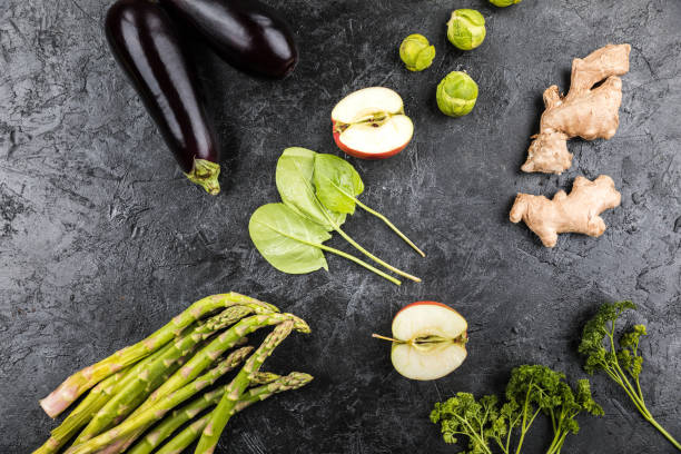 istock different green fresh seasonal vegetables on black table top background 673914632