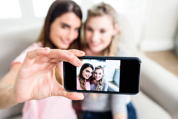istock Young female friends taking selfie at home 673915062
