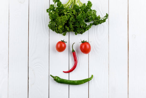 istock face made on different fresh seasonal vegetables on white wooden table background 673926508