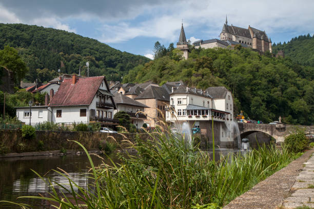 Picturesque Vianden town and medieval castle in Luxembourg, Europe Low angle view of the town, Our River and castle of Vianden, a small country village in the Ardennes region of Luxembourg. The castle sits on a green hill in the background. vianden stock pictures, royalty-free photos & images