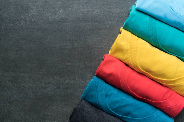 close up of rolled colorful clothes on black background - camisa de moleton imagens e fotografias de stock