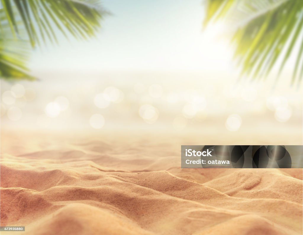 sand with blurred sea sky background, summer day Close up sand with blurred sea sky and plam leaf background, summer day, copy space or for product. Beach Stock Photo