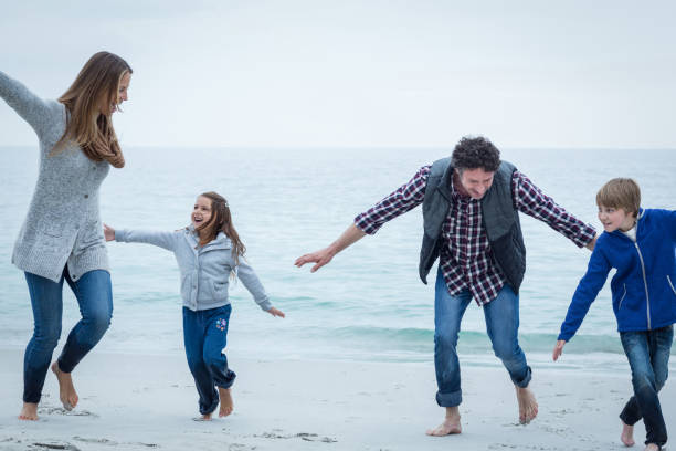istock Happy family playing at sea shore 673936948