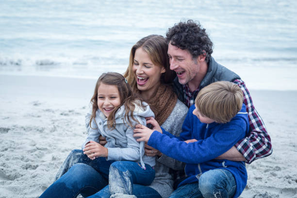 istock Cheerful family sitting at sea shore 673939536