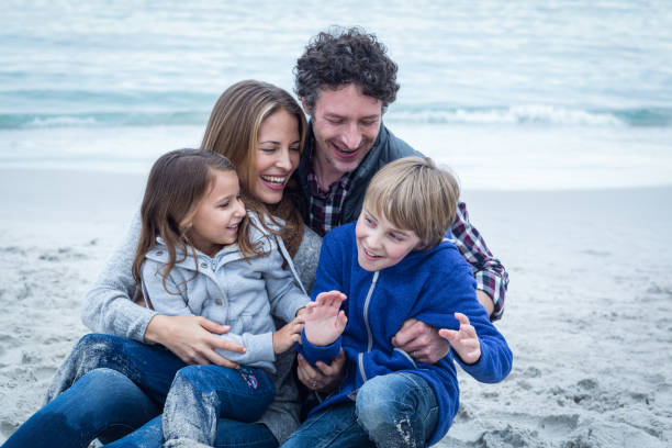 istock Cheerful parents with children at sea shore 673939572