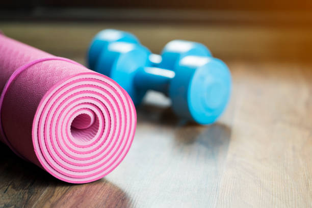 istock dumbbell and yoga mat on wood table 673943168