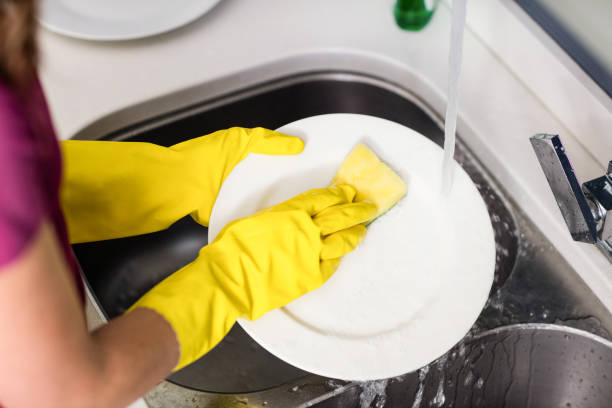istock Woman washing plate at kitchen washbasin 673943696