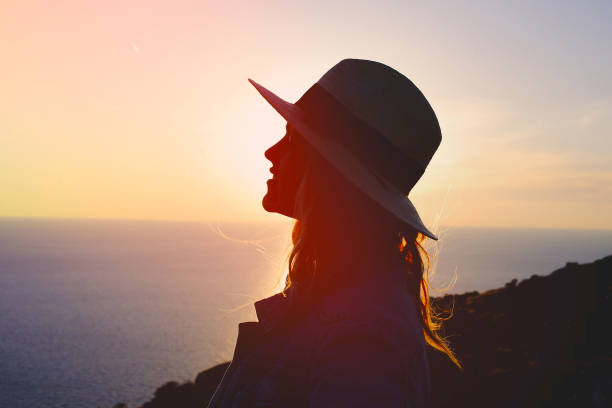 istock Young emotional woman enjoying sunset silhouette 673946532