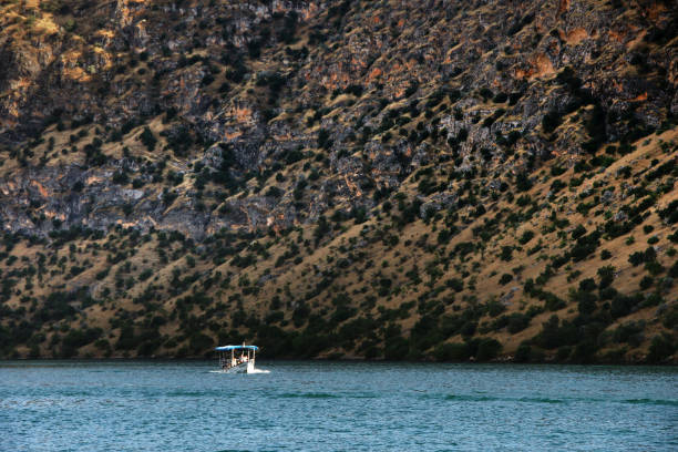 istock volcanic lake & a boat 673946702
