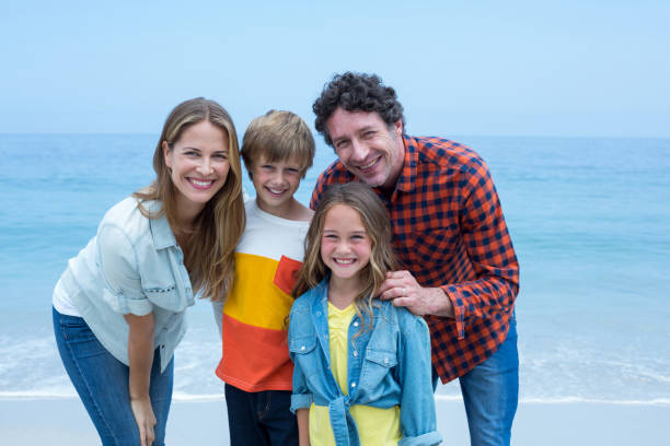istock Happy parents standing with children on shore 673964986