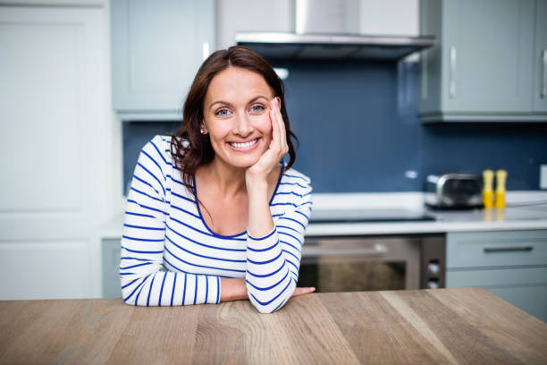 istock Cheerful young woman sitting at table 673968424