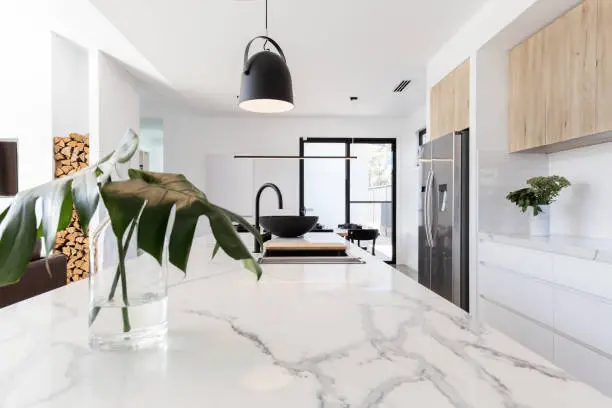 Photo of Kitchen marble bench close up with black hanging pendant