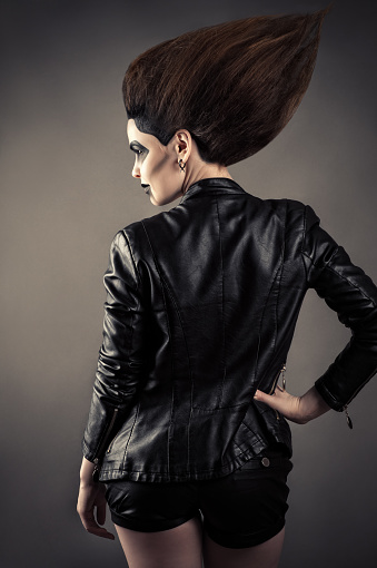 luxury woman with lush hair in leather jacket cut out gray background