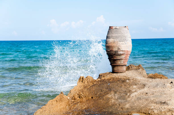 Amphora near rocky beach and sea background