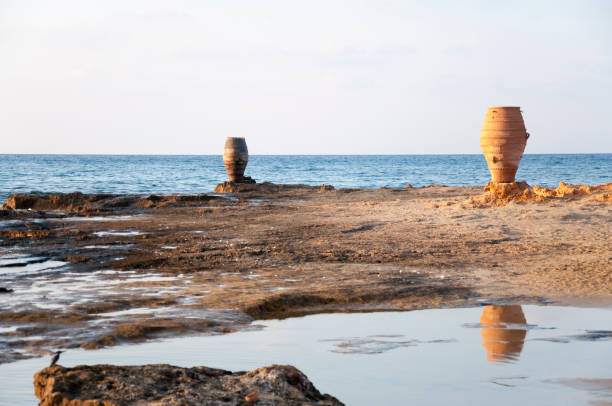 anfora sulla spiaggia rocciosa - greece crete beach island foto e immagini stock