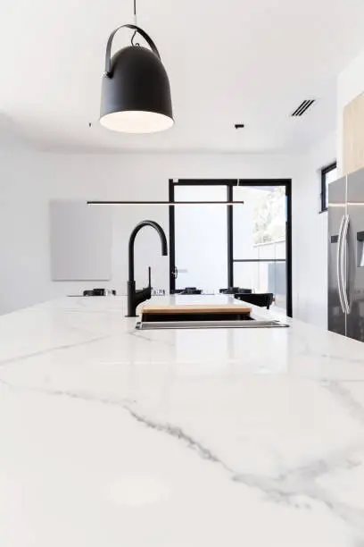 Carrera marble benchtop with black goose neck kitchen tap and black pendant