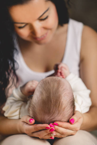 istock Cute newborn baby lying on his mother's lap 673991212