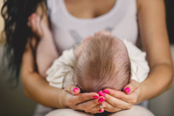 istock Cute newborn baby lying on his mother's lap 673991236