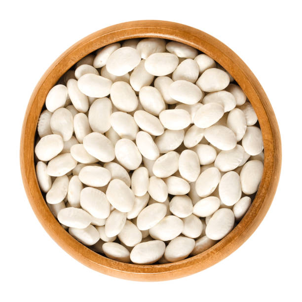 istock White navy beans in wooden bowl over white 673997042