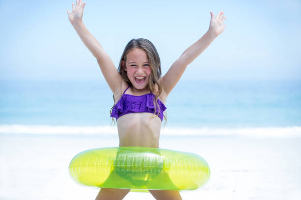 istock Girl with inflatable ring enjoying at sea shore 673998088