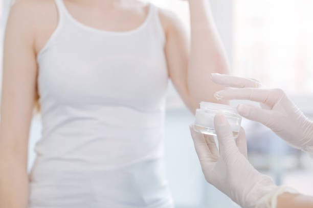 istock Skillful dermatologist applying medical cream on patient skin at work 674005718