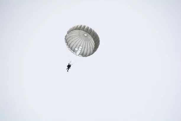 Photo of Parachute soldiers in the sky.