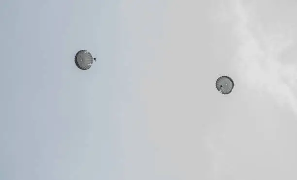 Photo of Two parachutes float in the sky.