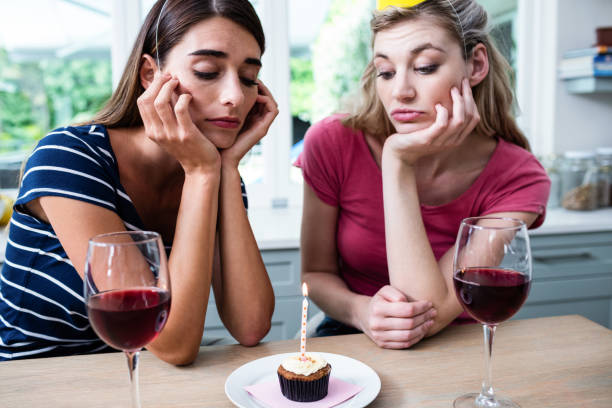 istock Unhappy friends sitting at table during birthday party 674016470
