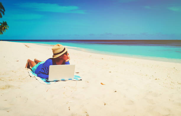 istock man with laptop on tropical beach 674017344