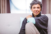 Portrait of smiling mature woman sitting on sofa
