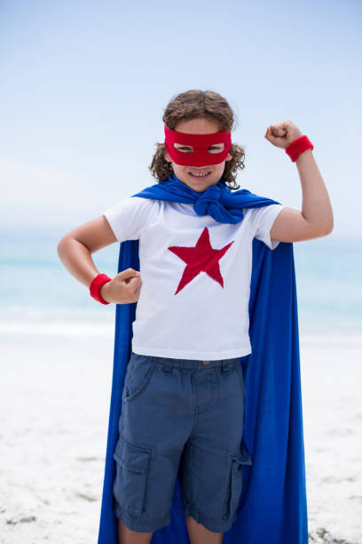 istock Boy in superhero costume standing at sea shore 674024218