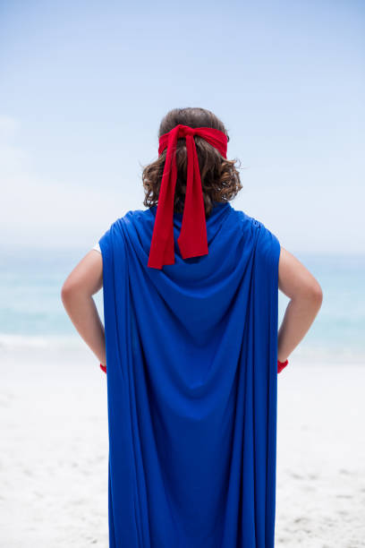 istock boy in superhero costume at sea shore 674024450
