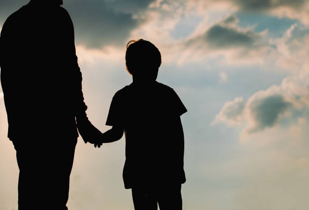 istock silhouette of father and son holding hands at sunset 674024972