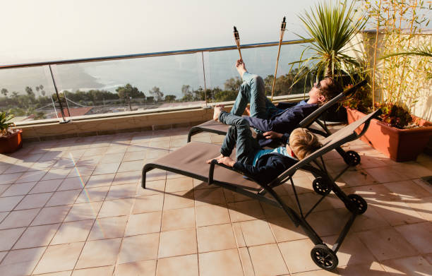 Dad and little son relax on balcony terrace