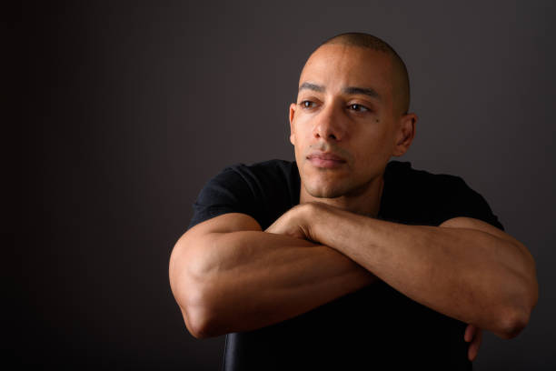Studio shot of mature handsome bald man against gray background horizontal shot