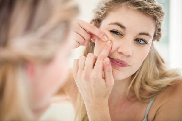 istock Concerned young woman looking in mirror while standing 674049568